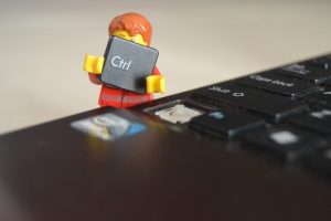 Lego man fixing computer keyboard